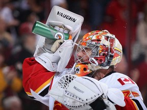 Calgary goaltender Joey MacDonald sprays water in his face during a game against the Phoenix Coyotes. McDonald, a former Red Wing, will be in net Friday when the Flames host Detroit.  (Christian Petersen/Getty Images)