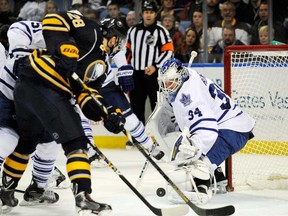 Buffalo's Zemgus Girensons, left, tries to take a shot on Toronto goalie James Reimer, right, during NHL action in Buffalo, N.Y., Friday, Nov. 29, 2013. (AP Photo/Gary Wiepert)