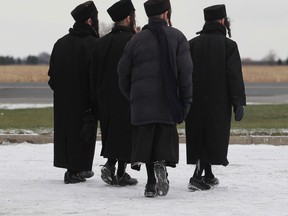 A group of young people from the Lev Tahor, a fundamentalist Jewish group, walk near St. Clair Road in Chatham, Ontario on November 28, 2013. (JASON KRYK/The Windsor Star)