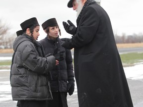 An elder speaks with two youths from the Lev Tahor, a fundamentalist Jewish group in Chatham, Ontario on November 28, 2013. (JASON KRYK/The Windsor Star)