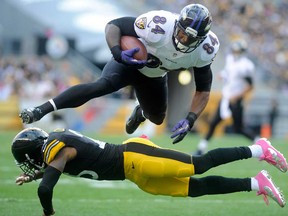 Baltimore's Ed Dickson, top, leaps over Pittsburgh's Ryan Clark October 20, 2013 in Pittsburgh. The Ravens host the Steelers in the late gameThursday. (Vincent Pugliese/Getty Images)