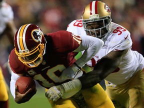 Washington QB Robert Griffin III, left, is sacked by outside linebacker Aldon Smith of the San Francisco 49ers November 25, 2013 in Landover, Maryland.  (Rob Carr/Getty Images)