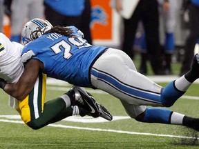 Green Bay quarterback Matt Flynn, left, is tackled by Detroit defensive end Willie Young at Ford Field in Detroit, Thursday, Nov. 28, 2013. (AP Photo/Duane Burleson)