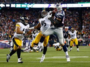 Rob Gronkowski, right, of the New England Patriots catches a pass in front of Jarvis Jones, centre, and Troy Polamalu of the Pittsburgh Steelers November 3, 2013 in Foxboro, Mass.  (Jared Wickerham/Getty Images)