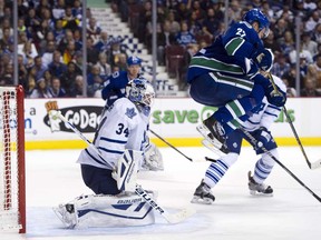 Vancouver's Daniel Sedin, right, jumps out of the way of a shot while standing in front of Toronto goalie James Reimer November 02, 2013 at Rogers Arena in Vancouver.  (Rich Lam/Getty Images)