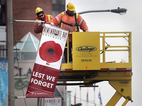 City workers install remembrance day flags along Riverside Dr. E in downtown Windsor, Ont. Wed. Nov. 6, 2013.(DAN JANISSE/The Windsor Star)