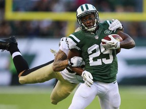 Bilal Powell, right, of the New York Jets carries  Kenny Vaccaro of the New Orleans Saints on his back during their game November 3, 2013 in East Rutherford, New Jersey.  (Al Bello/Getty Images)