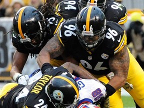 Pittsburgh's Ike Taylor, bottom left, Ziggy Hood, middle and Jarvis Jones, top, tackle Buffalo's Marquise Goodwin Sunday, Nov. 10, 2013, in Pittsburgh. (AP Photo/Don Wright)