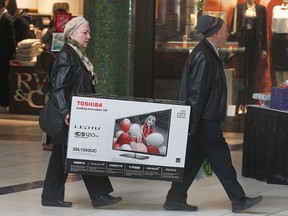 Miniona Tcherkezova, left, and Naum Ziskind carry a newly purchased television at the Devonshire Mall on Black Friday, Nov. 29, 2013, in Windsor, Ont.    (DAN JANISSE/The Windsor Star)