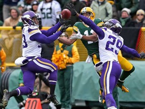 Minnesota's Jamarca Sanford, left, and Xavier Rhodes break up a pass intended for Green Bay's Jarrett Boykin at Lambeau Field on November 24, 2013 in Green Bay, Wisconsin. (Jonathan Daniel/Getty Images)