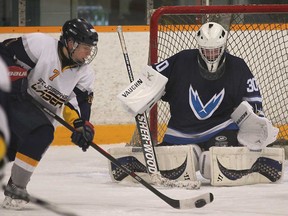 St. Joseph's Delaney MacDonald, left, closes in on Tecumseh Vista goalie Matthew Reaume during their game Wed. Nov. 27, 2013, at the Tecumseh Arena. (DAN JANISSE/The Windsor Star)