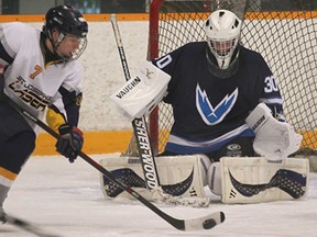 St. Joseph's Delaney MacDonald, left, closes in on Tecumseh Vista goalie Matthew Reaume during WECSSAA hockey action Wed. Nov. 27, 2013, at Tecumseh Arena.  (DAN JANISSE/The Windsor Star)