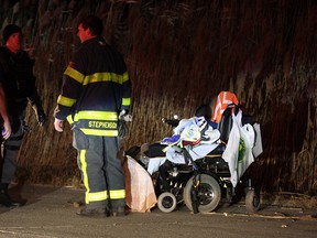 Firefighters and police confer by the motorized wheelchair in which a deceased 71-year-old woman was found in Windsor's east end on Nov. 27, 2013. (Nick Brancaccio / The Windsor Star)