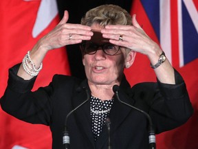 Ontario Premier Kathleen Wynne looks for someone in the crowd by shielding her eyes to the bright lights on Fri. Nov. 22, 2013, at a luncheon sponsored by the Windsor-Essex Regional Chamber of Commerce. (DAN JANISSE/The Windsor Star)