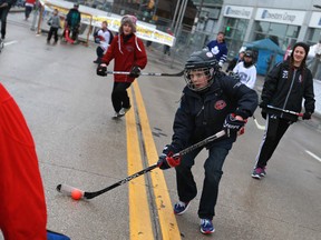 Jeffrey Smith, 8, takes a shot on goaltender, Trevor Ledrew, left, during the 2nd annual Windsor Classic in downtown Windsor, Saturday, Dec. 21, 2013.  The event raises money for the Downtown Mission. (DAX MELMER/The Windsor Star)