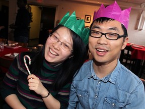 University of Windsor graduate students Shirley He, left, and Dan Liu, both of China, enjoy the festive spirit at Green Bean Cafe's annual Christmas Community dinner for those who are staying around the campus of University of Windsor, Wednesday, Dec. 25,  2013.  (NICK BRANCACCIO/The Windsor Star)