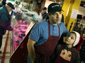 Dan Zaccagnini, owner of Zaccagnini Meats at the Market Square, is joined by his daughter, Olivia Zaccagnini, 9, while discussing the recent rise in the price of meats, Saturday, Dec. 7, 2013.  (DAX MELMER/The Windsor Star)