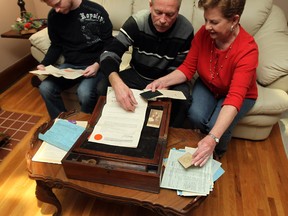 Brian, left, Keith and Marilyn Bremner look through a lap desk at their home in Windsor on Friday, Dec. 27, 2013. The small desk belonged to Keith's great-grandfather and was returned to the family after being sold at an auction many years ago. The box still contained photographs and important papers.                     (TYLER BROWNBRIDGE/The Windsor Star)