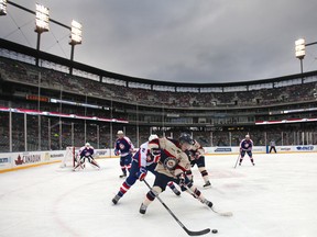 Windsor's Patrick Sandivo battles for the puck with Saginaw's Eric Locke during the OHL Outdoor Doubleheader between the Windsor Spitfires and the Saginaw Spirit at Comerica Park, Sunday, Dec. 29, 2013.  Windsor defeated Saginaw 6-5 in the first ever OHL game played outside.