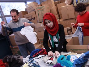 Volunteers help sort through donated clothing for Syrian refugees living in freezing conditions in Lebanon, at the Rose City Islamic Centre, Saturday, Dec. 21, 2013.  (DAX MELMER/The Windsor Star)