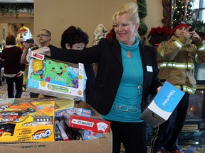 Files: Connie Filice, sales and marketing manager at Chartwell Oak Park Terrace, assists Windsor firefighters and Sparky as they collect an "unbelievable amount" of new, unwrapped toys from residents and staff at Oak Park Terrace on North Service Road, Tuesday December 10, 2013. The toy donations were greatly appreciated by firefighters who thanked residents and loaded the gifts, which are earmarked for needy families.  Sparky hung around and happily took photos with residents.  (NICK BRANCACCIO/The Windsor Star)