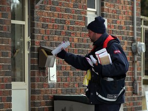 Shannor Allard of Canada Post delivers mail to a doorstep on Thompson Avenue in Riverside December 11, 2013. (NICK BRANCACCIO/The Windsor Star)
