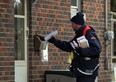 Shannor Allard of Canada Post delivers mail to a doorstep on Thompson Avenue in Riverside December 11, 2013. (NICK BRANCACCIO/The Windsor Star)