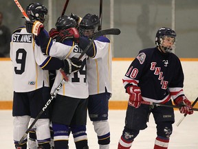 St. Anne's Tim Charlton, from left, Matt Zelko and Adrian Mainella celebrate a goal in front of Manny Silverio of Holy Names at the Tecumseh Arena.   (DAN JANISSE/The Windsor Star)