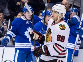 Chicago's Patrick Kane, front, skates past celebrating members of the Maple Leafs after Peter Holland, right, scored a goal (THE CANADIAN PRESS/Chris Young)