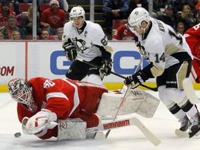 Pittsburgh's Chris Kunitz, right, takes a shot on Detroit goalie Jonas Gustavsson with Sidney Crosby watching at the side of the net Saturday in Detroit. (AP Photo/Duane Burleson)