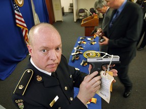 On April 23, 2009, U.S. and Canadian officials showed off the wares seized in Kentucky Bluegrass, the cross-border operation that smashed Riccardo Tolliver's gun smuggling ring. Here, Inspector Steve Clegg with the Ontario Provincial Police Weapons Enforcement division holds a seized gun. (Jason Kryk/The Windsor Star)