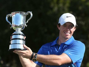 Rory MacIlroy of Northern Ireland holds up the Stonehaven Cup after winning the Australian Open golf tournament in Sydney Sunday, Dec. 1, 2013. MacIlroy defeated Australia's Adam Scott by one stroke finishing 18-under par. (AP Photo/Rob Griffith)