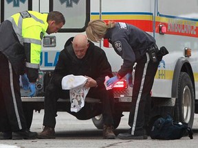 EMS tend to  a man after he was assaulted during an attempted robbery at the intersection of Victoria Ave. and Tecumseh Road West, Friday, Dec. 13, 2013.  (DAX MELMER/The Windsor Star)