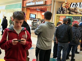 Boxing Day shoppers Brody Collison, left, plays Clash of Clans while waiting in line at EB Games at Devonshire Mall, December 26, 2013.  (NICK BRANCACCIO/The Windsor Star)