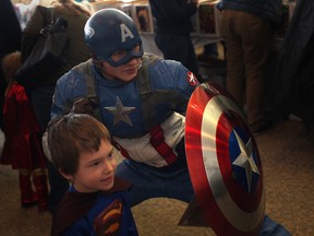 Reed McLean, 3, bottom, poses with Captain America at the Christmas Comic Con 2 at the St. Clair Centre for the Arts in Windsor, Ont., Sunday, Dec. 1, 2013.  (DAX MELMER/The Windsor Star)