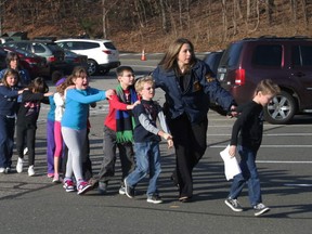 In this photo provided by the Newtown Bee, Connecticut State Police lead a line of children from the Sandy Hook Elementary School in Newtown, Conn. on Friday, Dec. 14, 2012 after a shooting at the school.  Recordings of 911 calls from the Newtown school shooting are being released Wednesday Dec. 4, 2013, days after a state prosecutor dropped his fight to continue withholding them despite an order to provide them to The Associated Press. (AP Photo/Newtown Bee, Shannon Hicks, File)