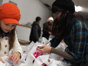 Files: Joli Michalczuk and her daughter, Ryli Michalczuk, 10, prepare canned goods and bread for the annual Mikhail Holdings turkey giveaway, on Dec. 20, 2013.  (DAX MELMER/The Windsor Star)