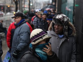 Hundreds lineup along the 300 block of Ouellette Ave. for the annual Mikhail Holdings turkey giveaway, Friday, Dec. 20, 2013. (DAX MELMER/The Windsor Star)