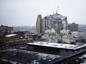 The Genesee Towers collapses on itself after demolition crews detonated charges to destroy the building on Sunday, Dec. 22, 2013 in downtown Flint, Mich. (AP Photo/The Flint Journal, Zack Wittman)