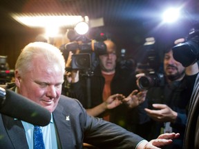 Toronto City Mayor Rob Ford shoves his way through members of the media as he leaves an Executive Committee meeting at Toronto's City Hall on Thursday December 5 2013. (THE CANADIAN PRESS/Chris Young)