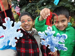 Students from Brock grade school helped decorate the large Christmas tree, Wednesday, Dec. 4, 2013, at Mackenzie Hall in Windsor, Ont. The children put up handmade ornaments then had a gathering with hot chocolate and candy. Tahsan Akib, left, and Ayan Khan display their ornaments. (DAN JANISSE/The Windsor Star)