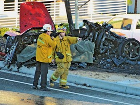 First responders gather evidence near the wreckage of a Porsche sports car that crashed into a light pole on Hercules Street near Kelly Johnson Parkway in Valencia on Saturday, Nov. 30, 2013. A publicist for actor Paul Walker says the star of the "Fast & Furious" movie series has died in a car crash north of Los Angeles. He was 40. Ame Van Iden says Walker died Saturday afternoon. No further details were released. (AP Photo/The Santa Clarita Valley Signal, Dan Watson)