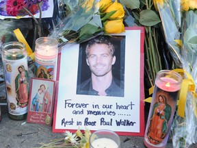 A photo of actor Paul Walker is seen December 1, 2013 among flowers and candles left by fans at the site of the car accident in which the "Fast and Furious" actor and another man died the previous day, in Santa Clarita, California.  Santa Clarita police warned fans Monday against "burning rubber" near the spot where the car Walker was a passenger in crashed, as they continued to probe the accident.  Police issued the caution after reports of people pulling stunt maneuvers on the stretch of road in town northwest of Los Angeles, where Walker died on Saturday.  (ROBYN BECK/AFP/Getty Images