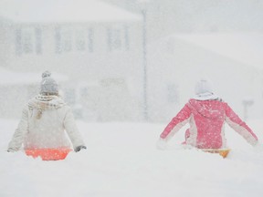 Madison Pierce (left), 13, and Gracie Maher, 11, slowly slide along their neighborhood streets as the first snow of the season rolls into Hockessin, Del. and the region, Sunday, Dec. 8, 2013. (AP Photo/The News-Journal, Suchat Pederson) O