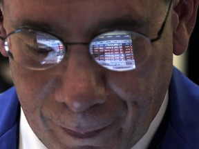 In this Tuesday, March 5, 2013, file photo, the glasses of trader Sal Suarino reflect the screen of his handheld device, as he works on the floor of the New York Stock Exchange. While 2013 was a great year for the average investor, few market strategists believe that 2014 will be anywhere near as good. (AP Photo/Richard Drew, File)