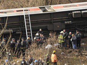 Emergency workers at the scene of a commuter train wreck on Dec 1, 2013 in the Bronx borough of New York. The train bound for New York's Grand Central Station derailed in the Bronx Sunday with at least four people reported dead after several rail cars left the tracks near the Spuyten Duyvil railroad station. The southbound train was travelling from Poughkeepsie to Grand Central Terminal when the accident occurred. (TIMOTHY CLARY/AFP/Getty Images)