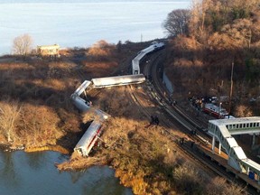 Cars from a Metro-North passenger train are scattered after the train derailed in the Bronx neighbourhood of New York, Sunday, Dec. 1, 2013. The Fire Department of New York says there are "multiple injuries" in the  train derailment, and 130 firefighters are on the scene. Metropolitan Transportation Authority police say the train derailed near the Spuyten Duyvil station. (AP Photo/Edwin Valero)
