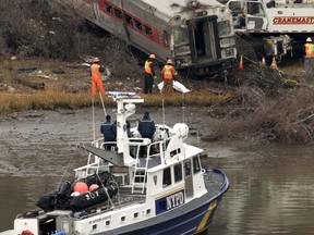 Cranes salvage the last car from a train derailment in the Bronx section of New York, Monday, Dec. 2, 2013. Federal authorities began righting the cars Monday morning as they started an exhaustive investigation into what caused a Metro-North commuter train rounding a riverside curve to derail, killing four people and injuring more than 60 others. A second "event recorder" retrieved from the train may provide information on the speed of the train, how the brakes were applied, and the throttle setting, a member of the National Transportation Safety Board said Monday. (AP Photo/Mark Lennihan)