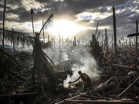 A man fans flames on a fire Tanauan on November 19, 2013 in Leyte, Philippines. Typhoon Haiyan which ripped through Philippines over a week ago has been described as one of the most powerful typhoons ever to hit land, leaving thousands dead and hundreds of thousands homeless. Countries all over the world have pledged relief aid to help support those affected by the typhoon however damage to the airport and roads have made moving the aid into the most affected areas very difficult. With dead bodies left out in the open air and very limited food, water and shelter, health concerns are growing.  (Dan Kitwood/Getty Images)