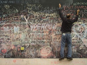 A man writes a message on the ''Before I die'' wall on September 25, 2013 in Prague where people can write in chalk what they would like to do before they die. (MICHAL CIZEK/AFP/Getty Images)